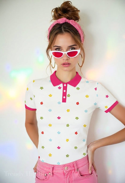 Mod 60s floral polo shirt with UPF 50+ sun protection. Unisex vintage-inspired polo featuring a white background, colorful floral print, and fuchsia pink trim.